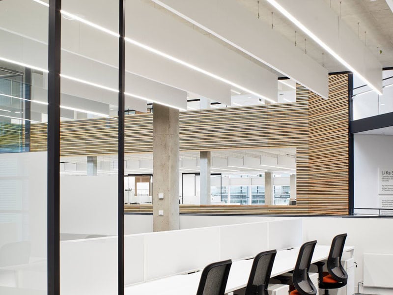 Blade indbygget i akustik bafler nedhængt fra loft i åbent kontormiljø - Luminex