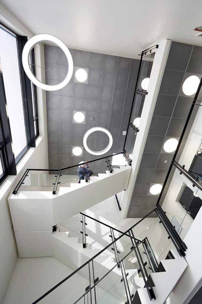 Ledgo Circle panel indbygget i loft med Ringo Star cirkulær lampe nedhængt fra loft ved trapperne - Luminex