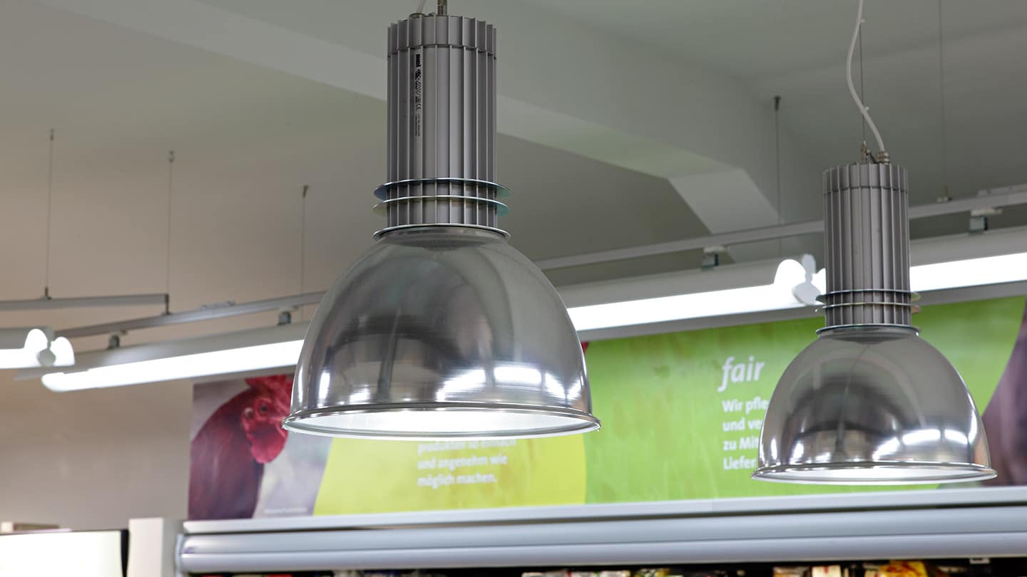 pendel lampe nedhængt fra loft over disk i butik nærbillede - Luminex